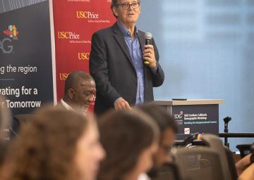 Man speaking at podium during a conference.