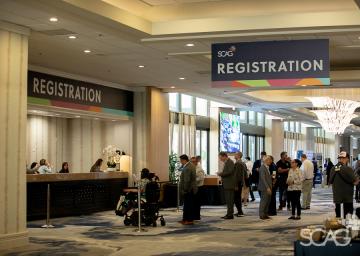 GA26 Conference registration area with people at the counter.