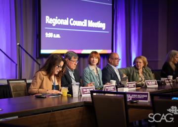 Panel discussion at a Regional Council Meeting, people seated at a conference table.