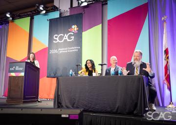 Panelists speaking at a conference with colorful backdrop and SCAG logo.